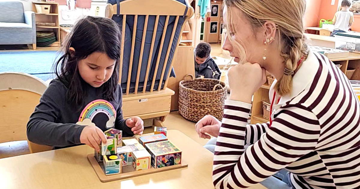 Child and teacher play with blocks together.